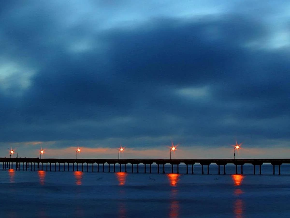 A pier and the shoreline at dusk in Pacific Beach.